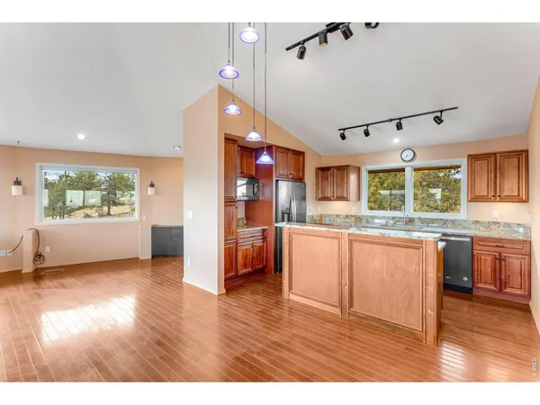 a kitchen with stainless steel appliances wooden floor and refrigerator