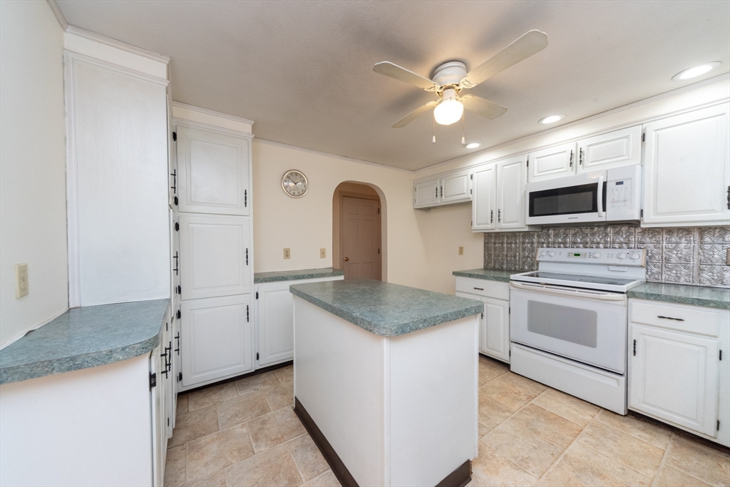 205 Beaman Road Sterling, MA 01564 - Photo 11 of 41 a kitchen with granite countertop a sink stainless steel appliances and white cabinets