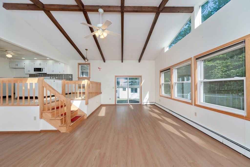 205 Beaman Road Sterling, MA 01564 - Photo 7 of 41 a view of an empty room with wooden floor windows and a chandelier
