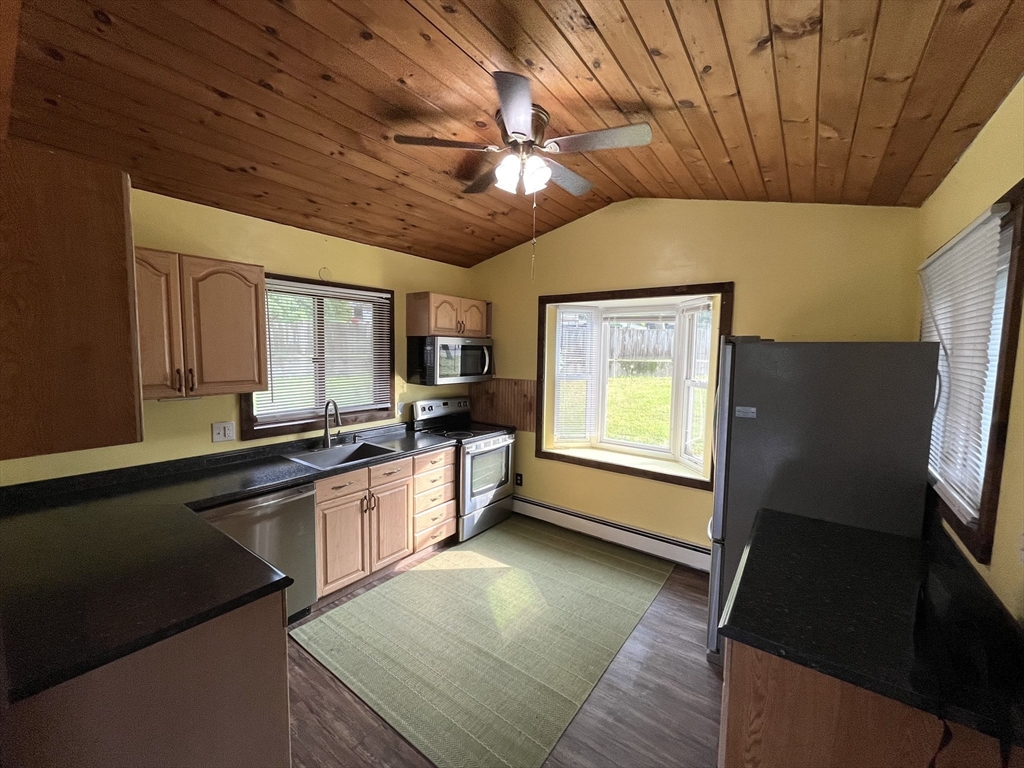 56 Shore Drive Upton, MA 01568 - Photo 6 of 23 a large kitchen with stainless steel appliances granite countertop a refrigerator a sink dishwasher a stove and white countertops with wooden floor