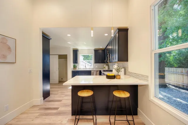 a kitchen with stainless steel appliances granite countertop a refrigerator stove top oven and sink