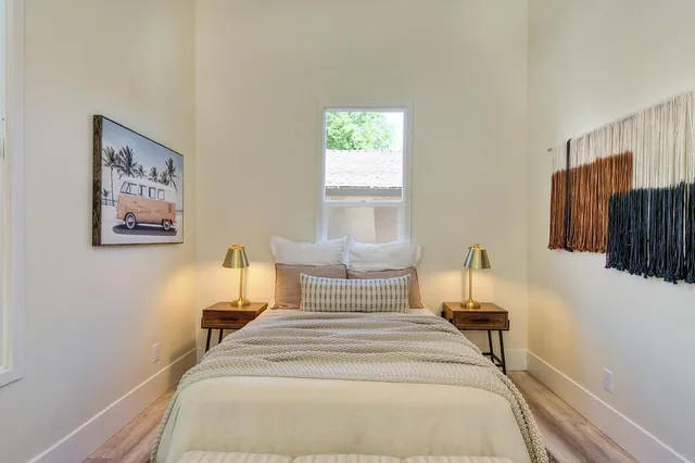 a view of a backyard with wooden fence and a large tree
