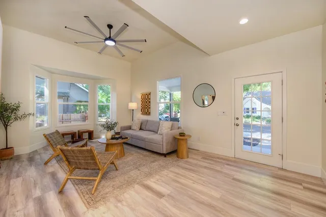 a dining room with wooden floor a chandelier a wooden table and chairs