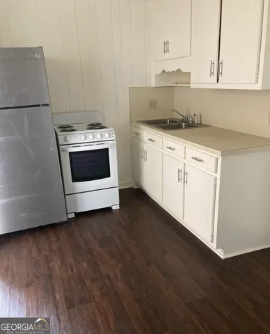 a kitchen with white cabinets and white appliances