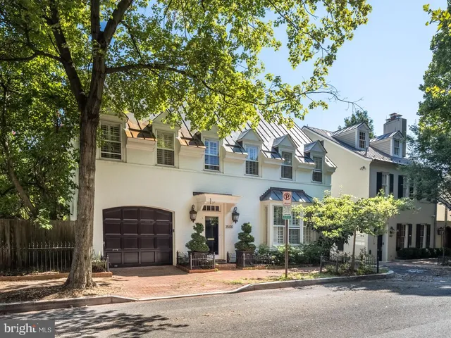 a front view of a house with a tree