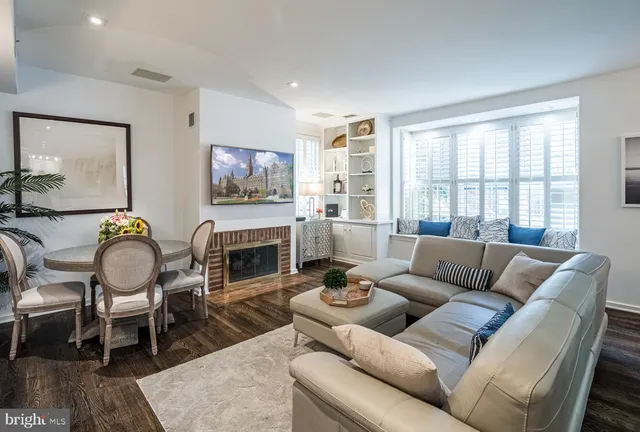 a living room with furniture a fireplace and a large window