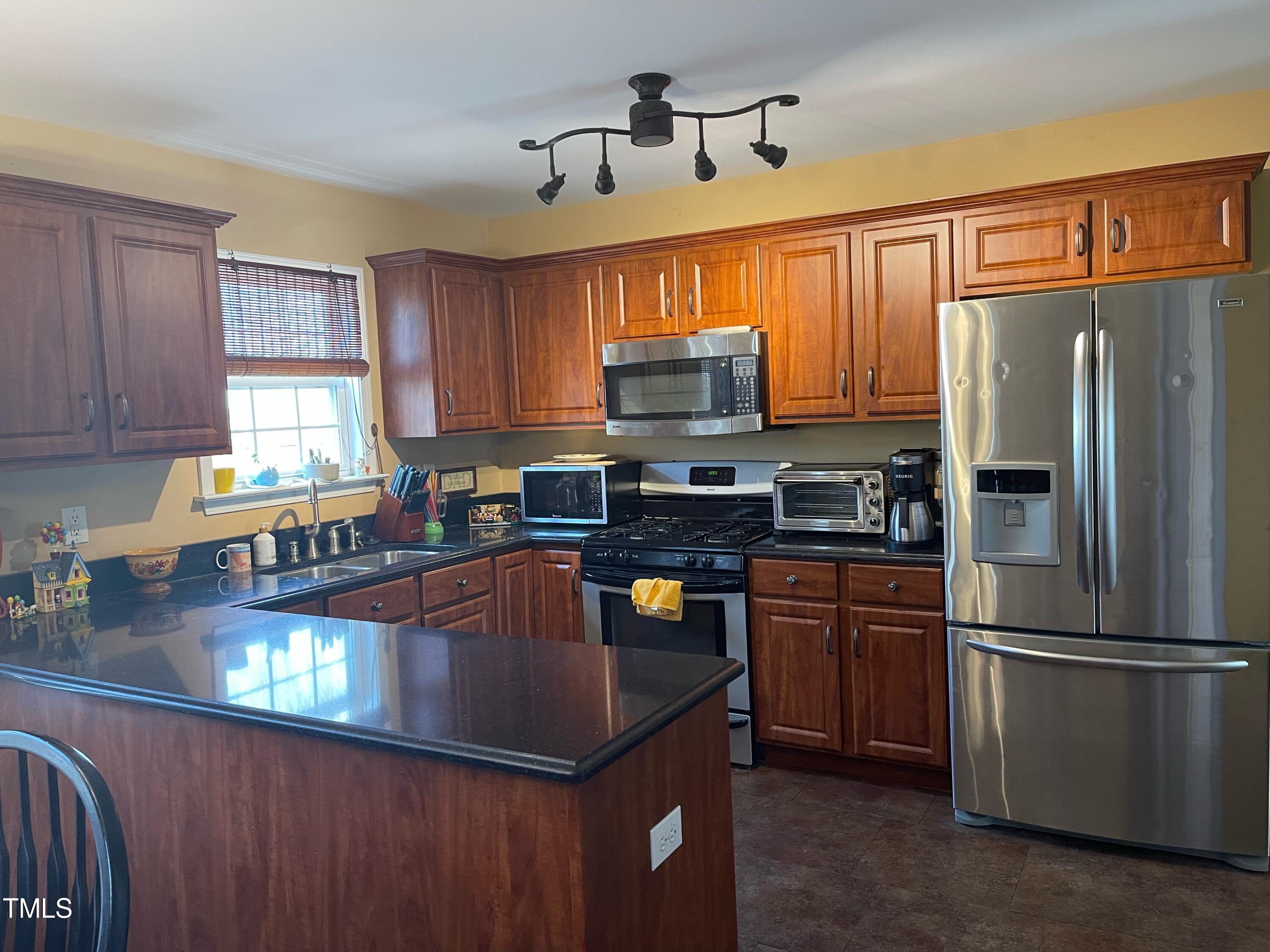 112 Grassy Valley Road Holly Springs, NC 27540 - Photo 14 of 39 a kitchen with granite countertop stainless steel appliances a refrigerator a stove a sink cabinets and a dining table