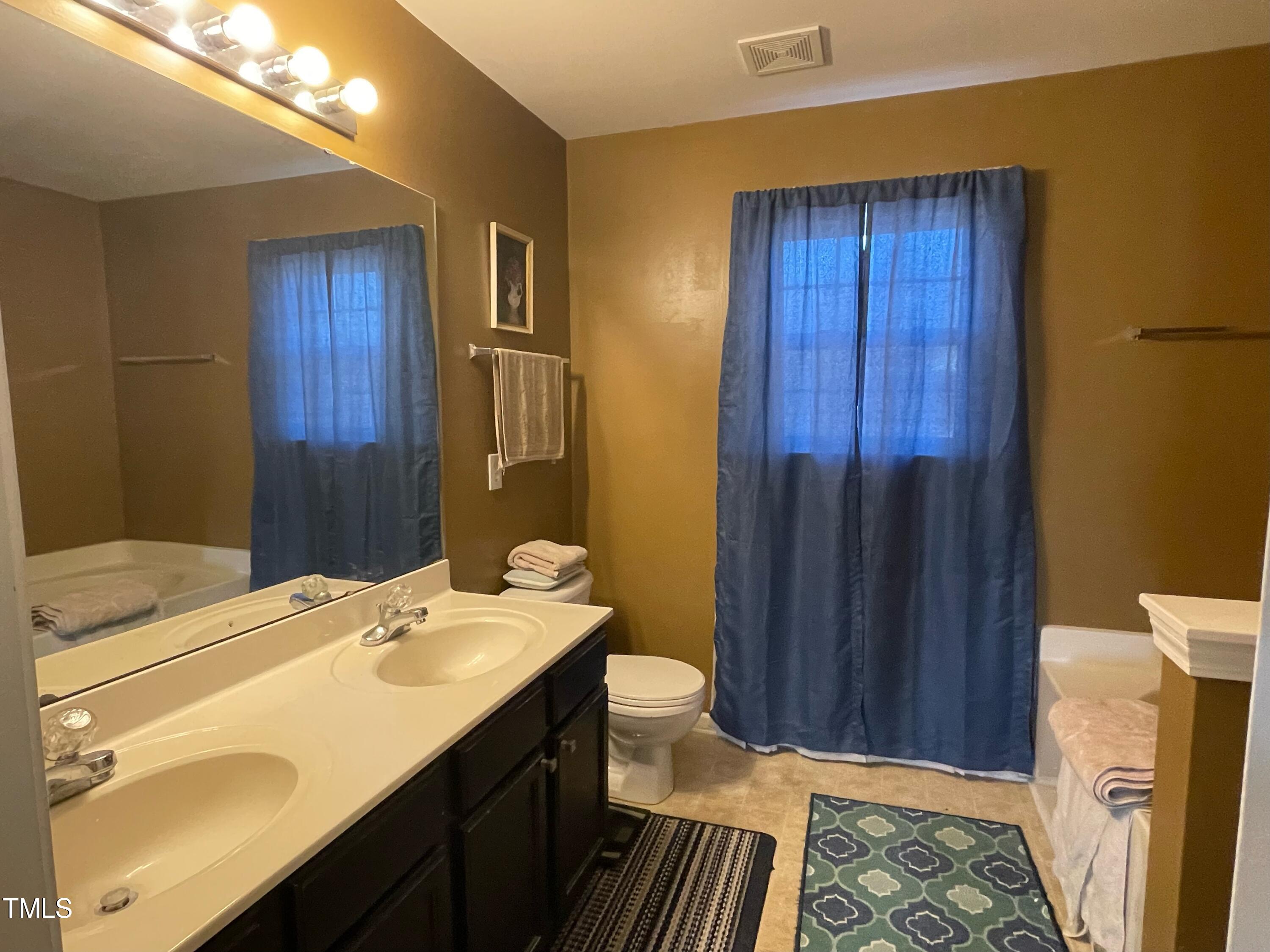 112 Grassy Valley Road Holly Springs, NC 27540 - Photo 28 of 39 a bathroom with a sink a toilet and shower