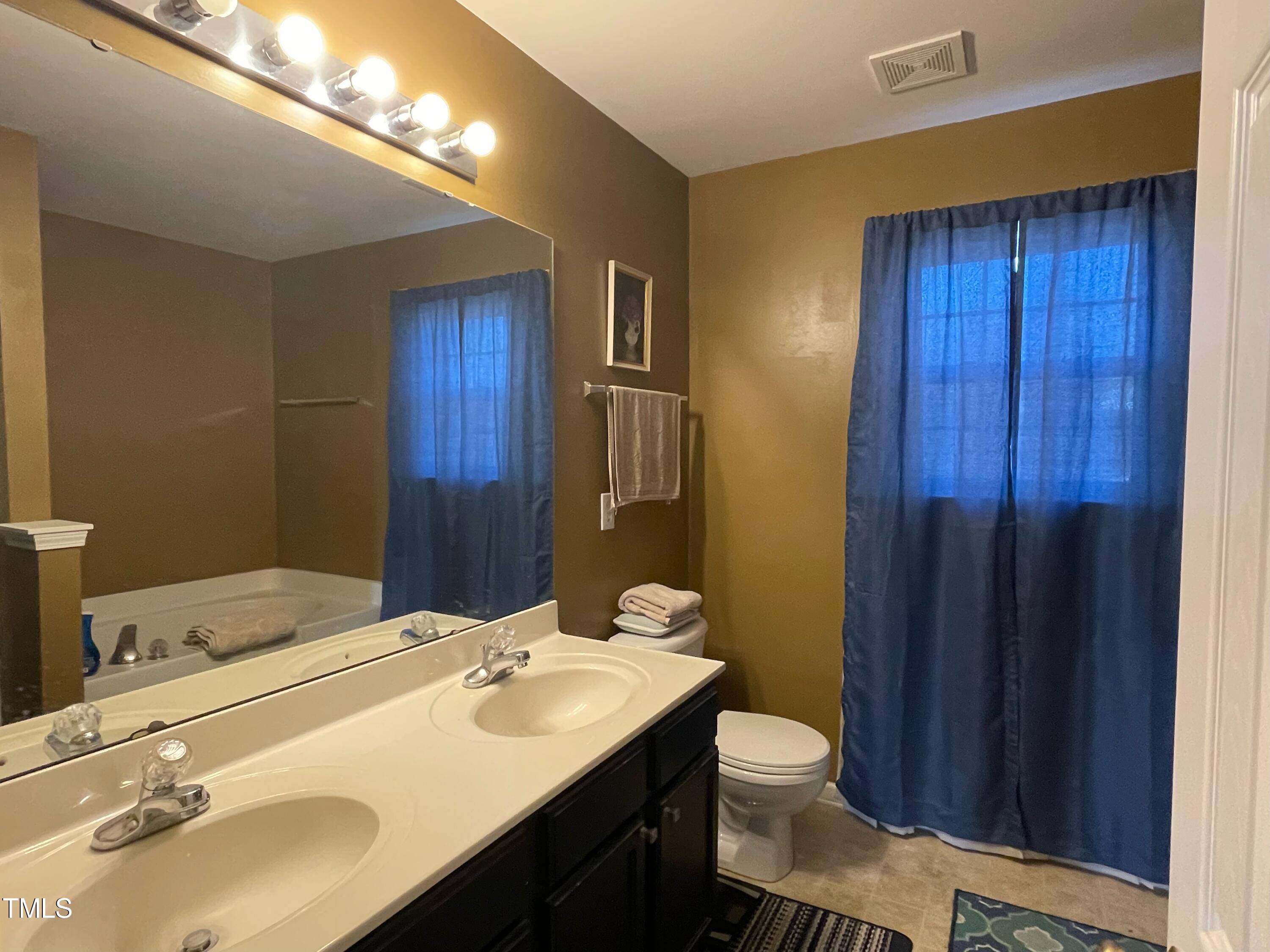 112 Grassy Valley Road Holly Springs, NC 27540 - Photo 29 of 39 a bathroom with a sink and a mirror