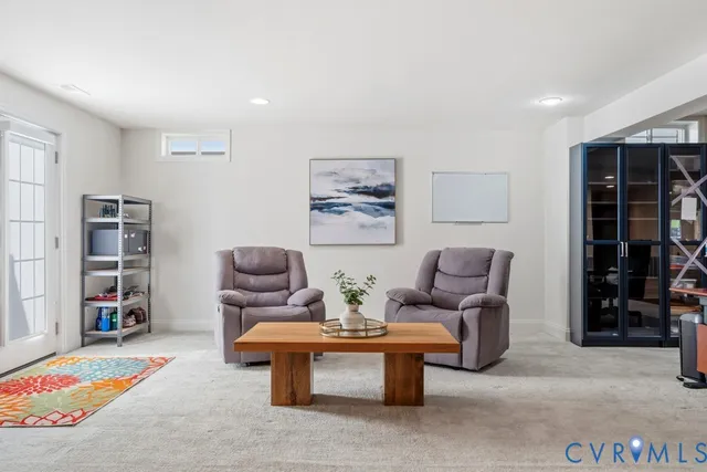 a living room with furniture a bookshelf and a wooden floor