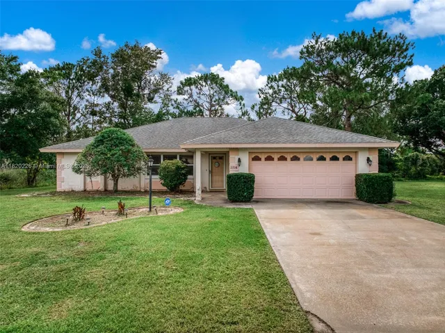 a view of a house with backyard and a tree