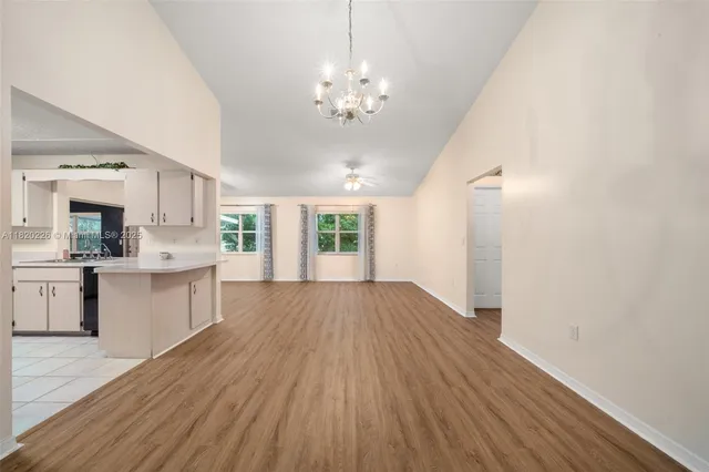 an empty room with windows and ceiling fan
