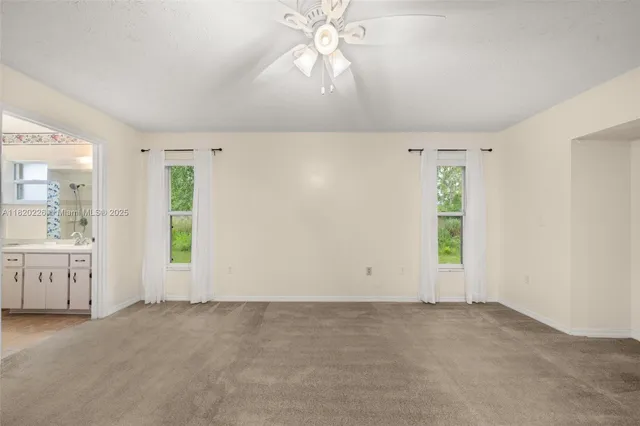 an empty room with chandelier fan