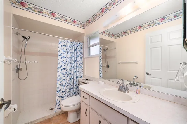 a view of a livingroom with a chandelier fan and a window