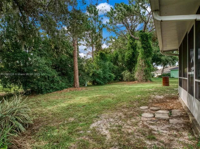 an aerial view of residential houses with outdoor space and trees