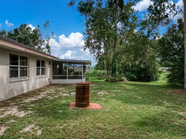 an aerial view of residential houses with outdoor space and trees
