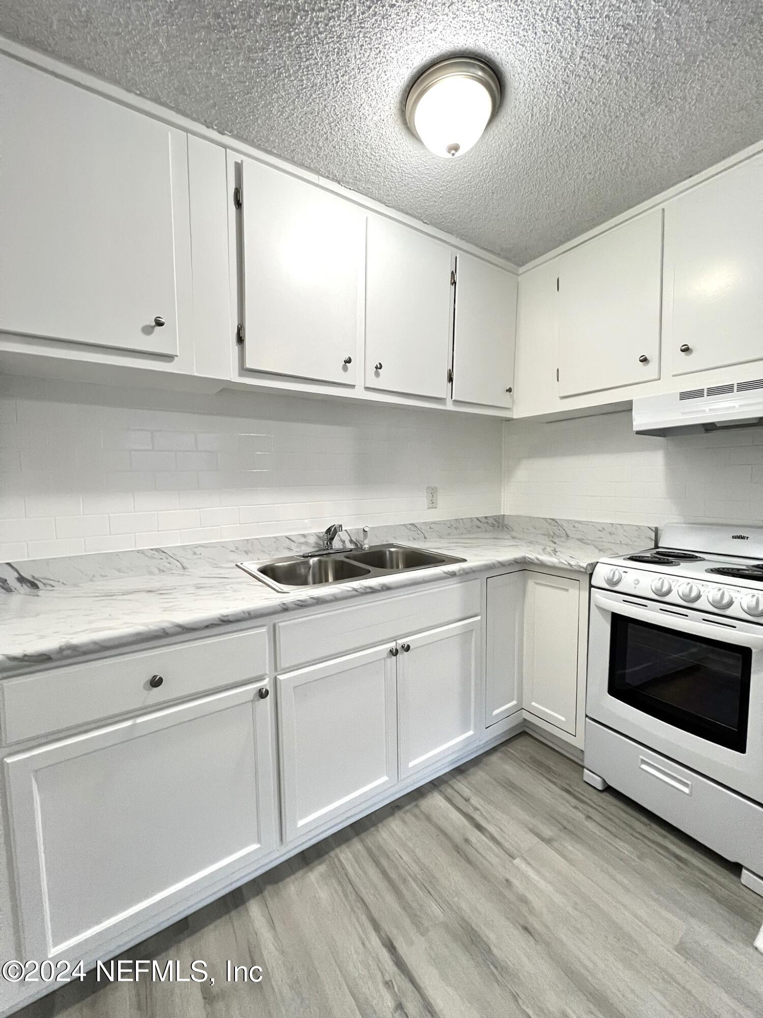 2704 Forman Circle Middleburg, FL 32068 - Photo 4 of 14 a kitchen with granite countertop white cabinets and white appliances