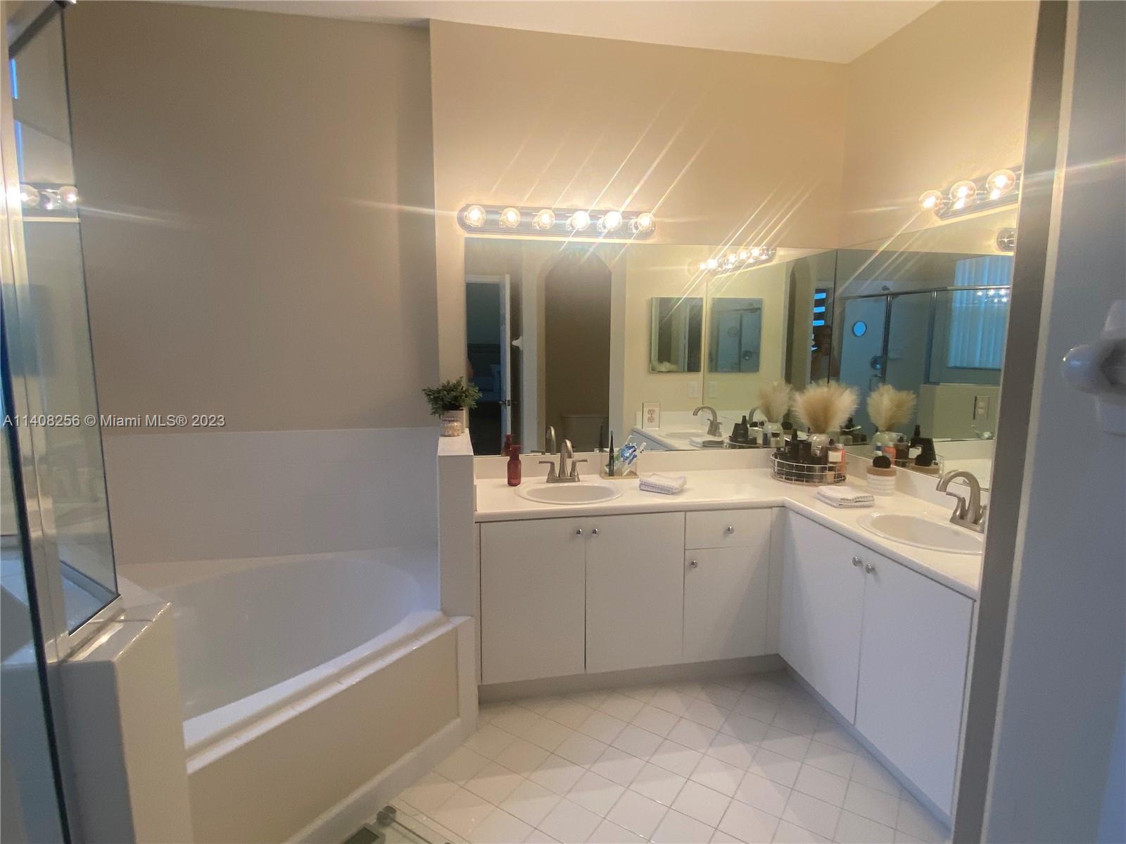 12812 Southwest 134th Terrace Miami, FL 33186 - Photo 18 of 41 a bathroom with a tub sink and mirror