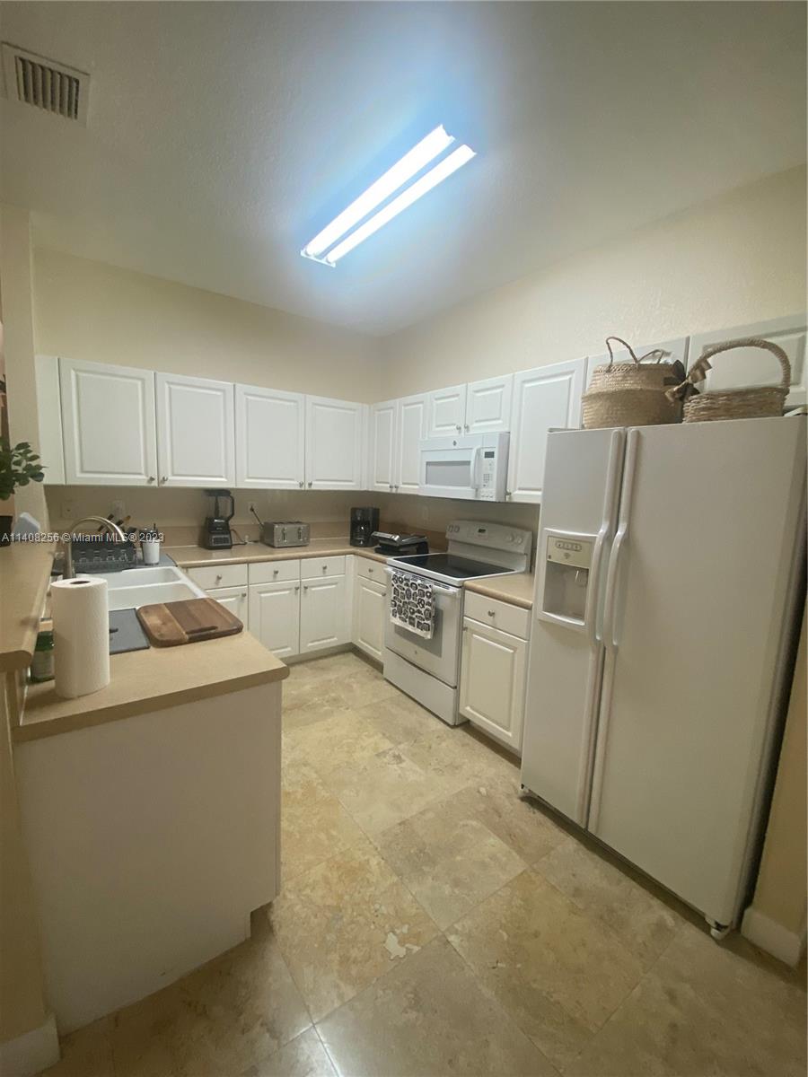 12812 Southwest 134th Terrace Miami, FL 33186 - Photo 10 of 41 a kitchen with cabinets and white stainless steel appliances