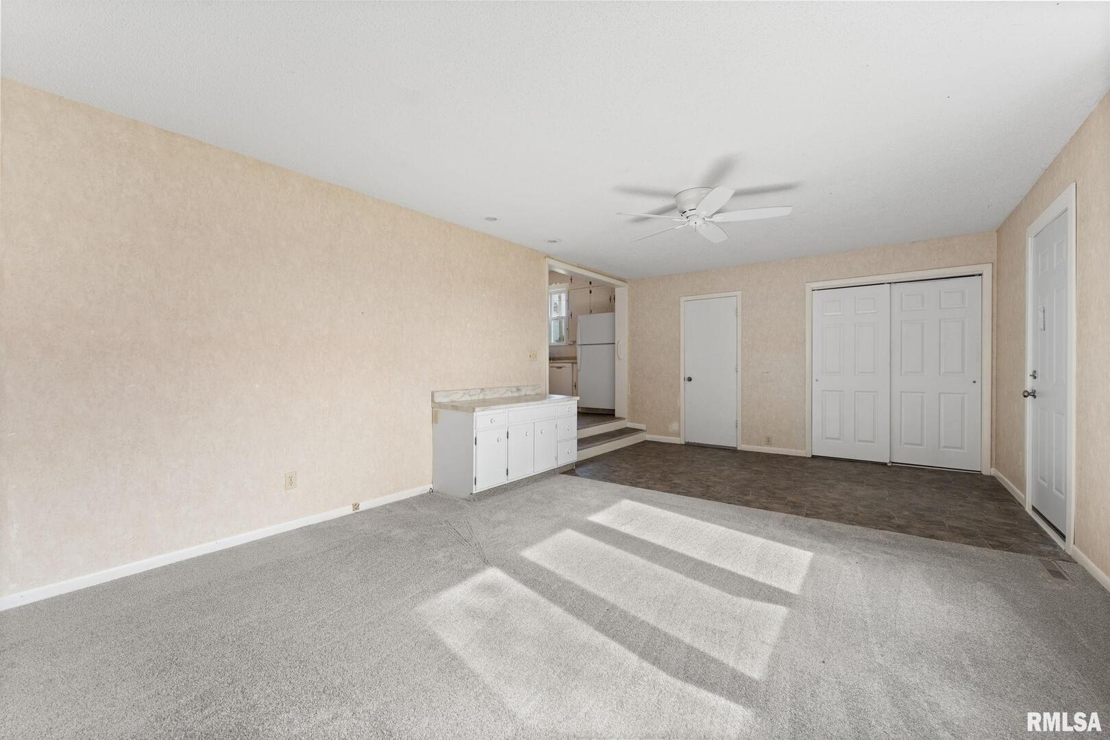 2442 Mittman Road Muscatine, IA 52761 - Photo 17 of 24 wooden floor in an empty room with a ceiling fan
