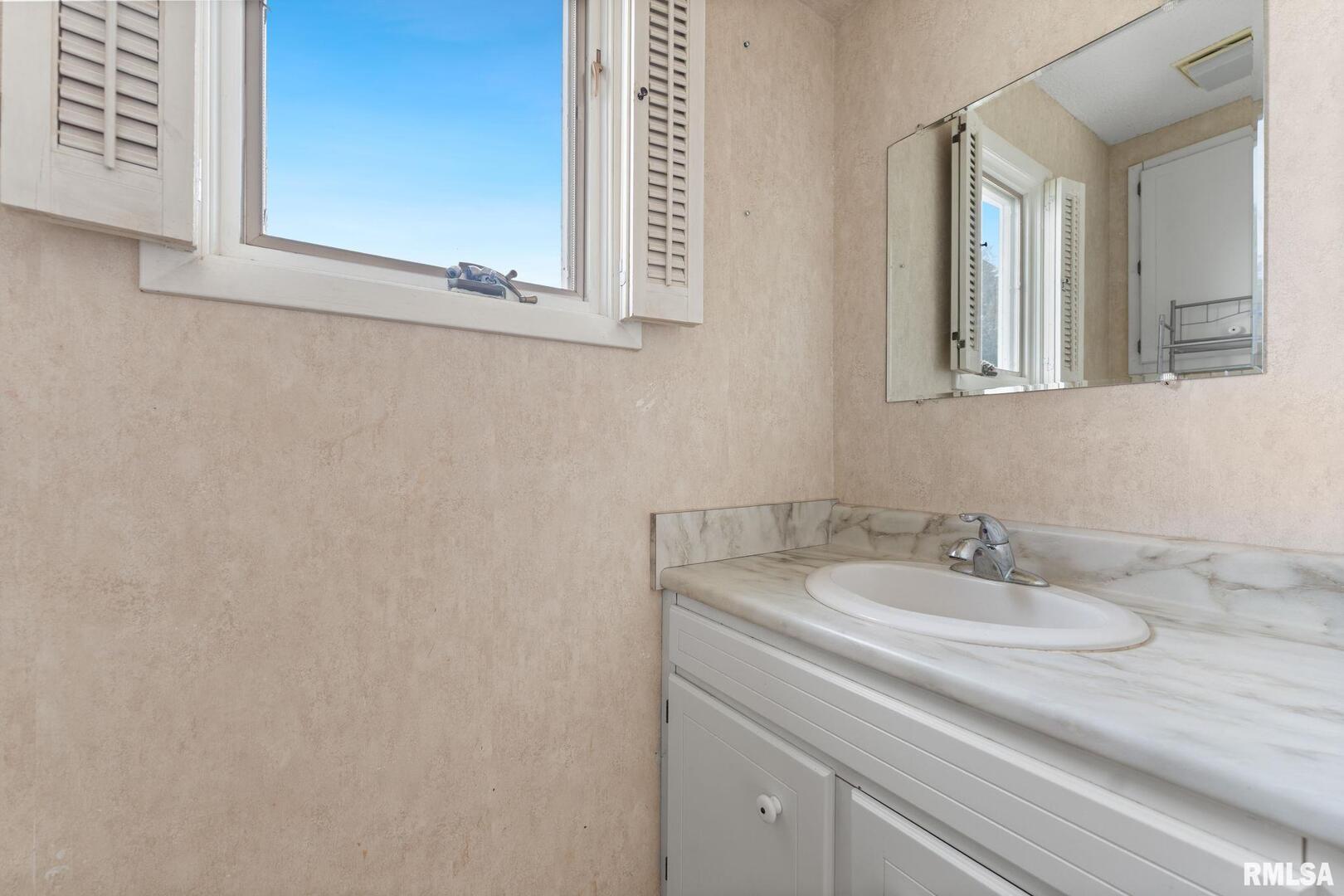 2442 Mittman Road Muscatine, IA 52761 - Photo 18 of 24 a bathroom with a sink and a mirror
