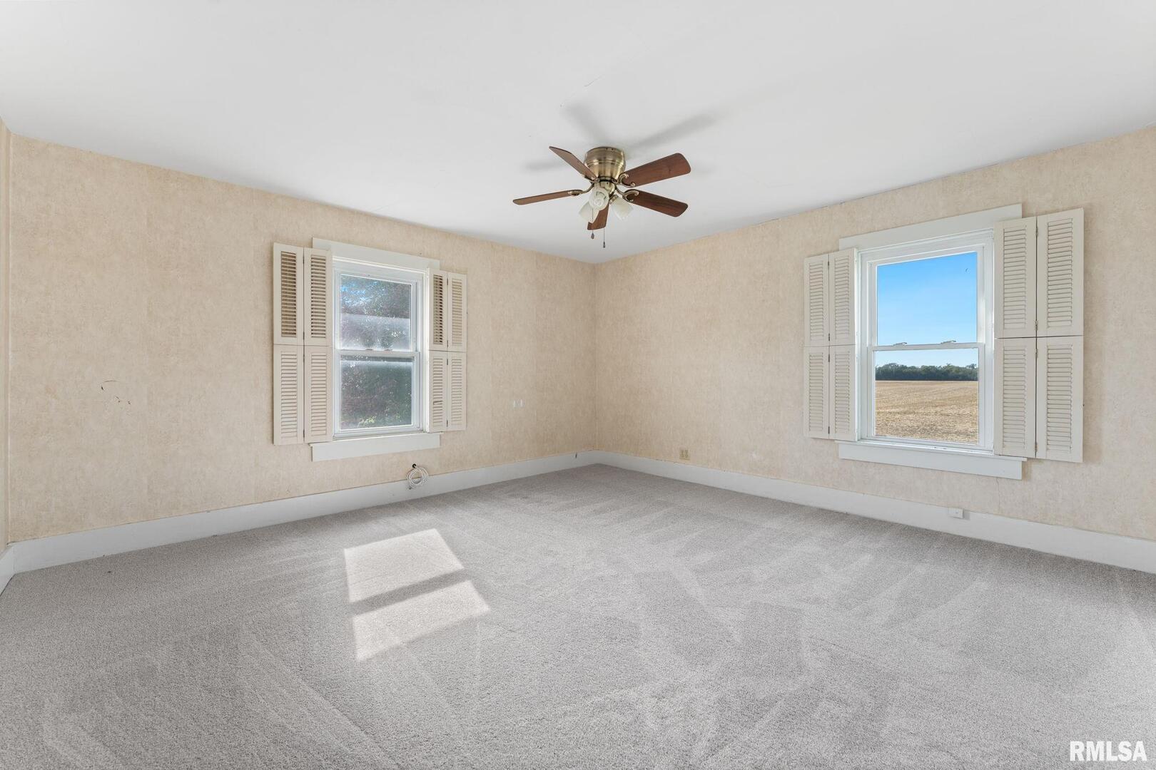 2442 Mittman Road Muscatine, IA 52761 - Photo 23 of 24 an empty room with windows and ceiling fan