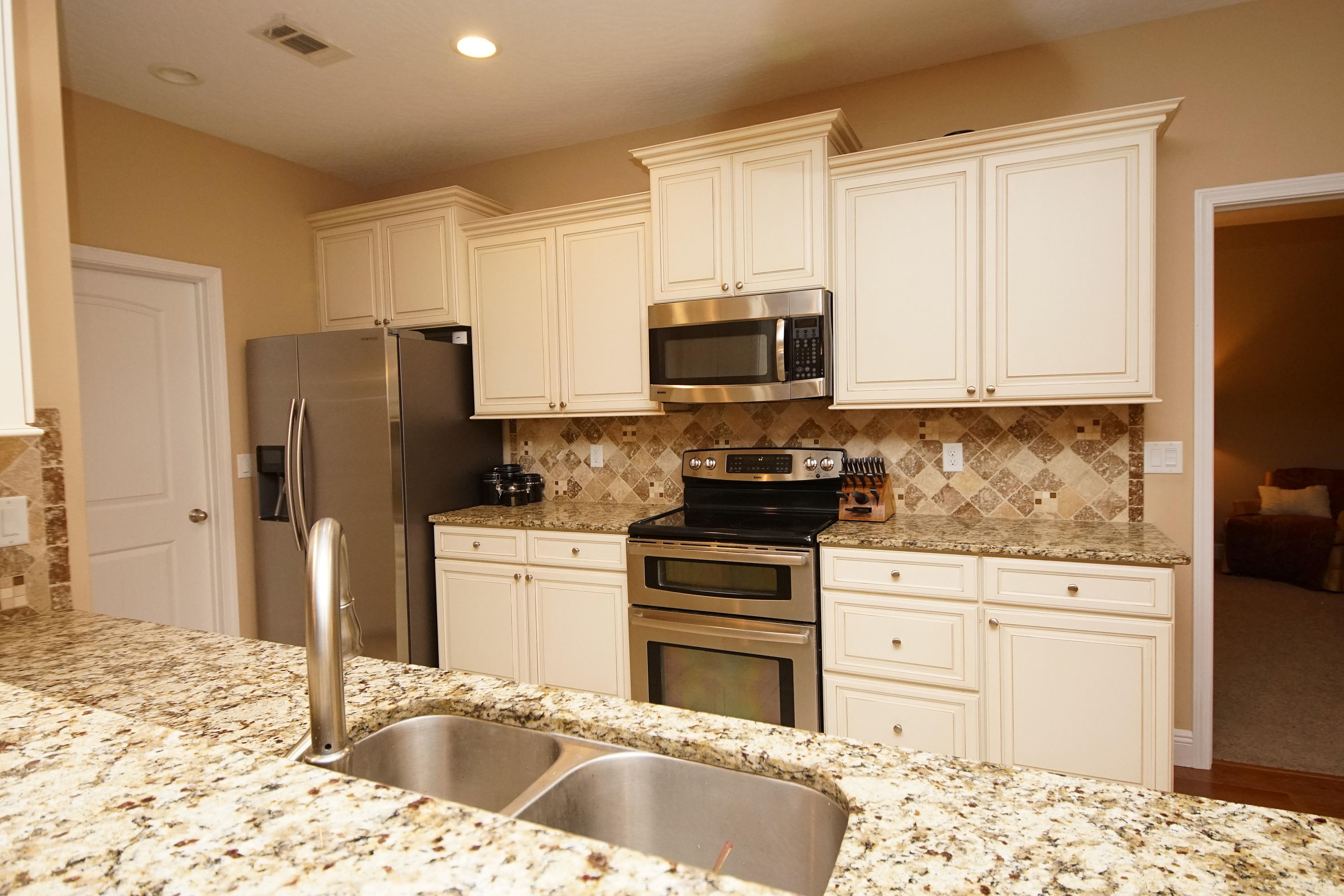 616 Lang Road Fort Walton Beach, FL 32547 - Photo 17 of 54 a kitchen with granite countertop a refrigerator and a stove top oven