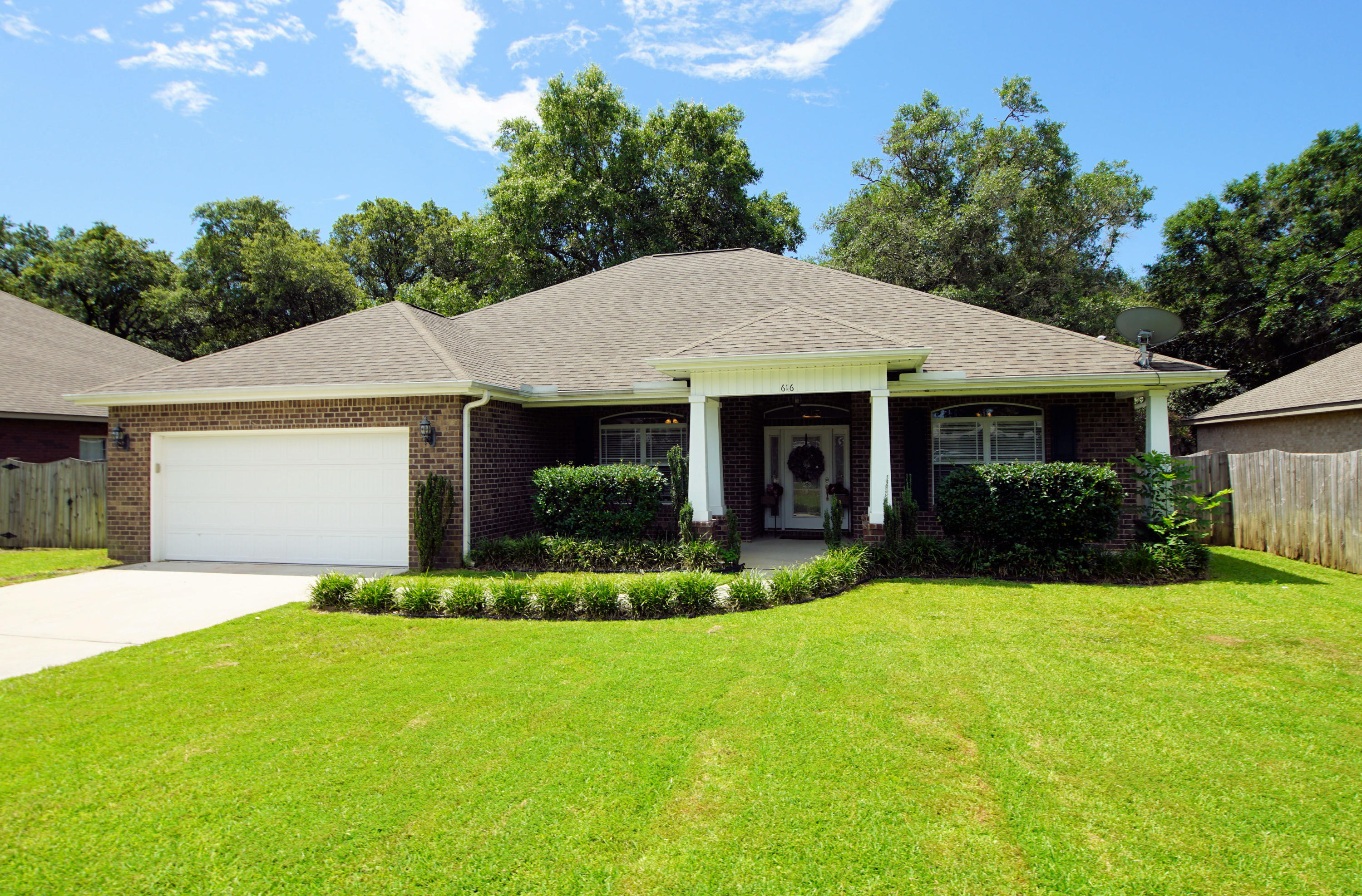 616 Lang Road Fort Walton Beach, FL 32547 - Photo 5 of 54 a front view of a house with a yard and garage