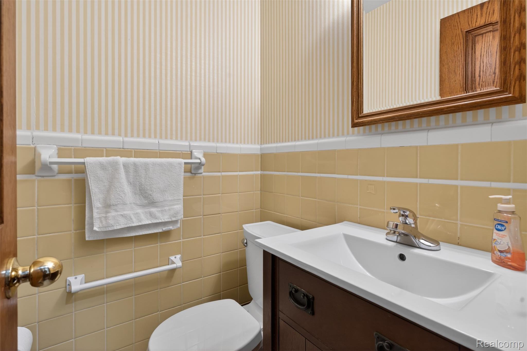 15623 Millar Road Clinton Township, MI 48036 - Photo 51 of 56 Power Room featuring wallpapered walls, vanity, tile walls, and a wainscoted wall