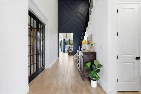 a hallway with wooden floor and some plants