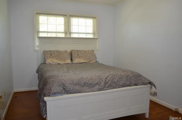 a kitchen with granite countertop a refrigerator a stove a sink dishwasher and white cabinets with wooden floor