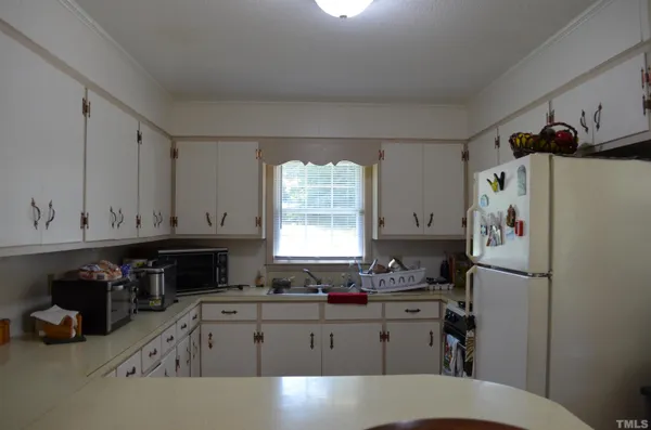 a kitchen with a refrigerator a stove a sink and a window