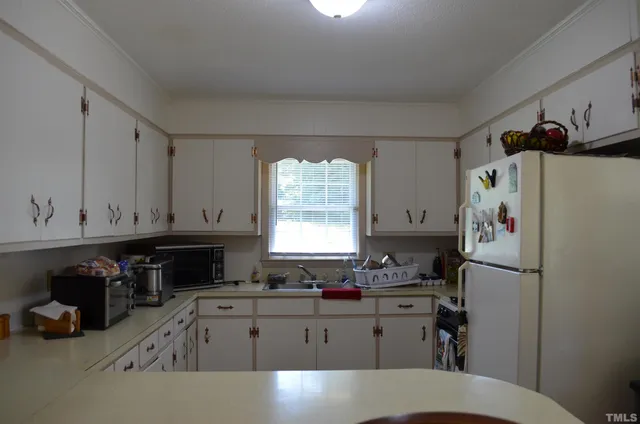 a kitchen with a refrigerator a stove a sink and a window
