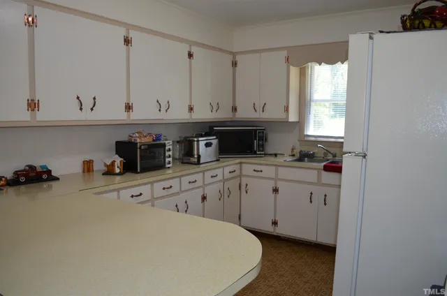 a kitchen with cabinets appliances and a window