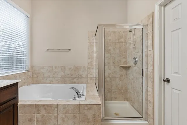 a bathroom with a shower and a bath tub