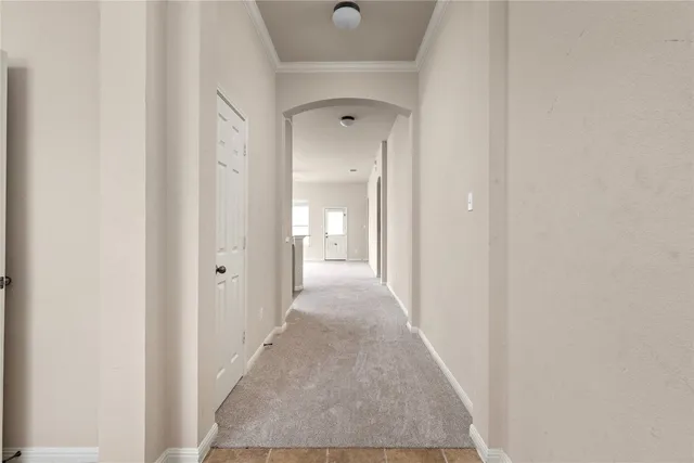 a view of a hallway with wooden floor and a door