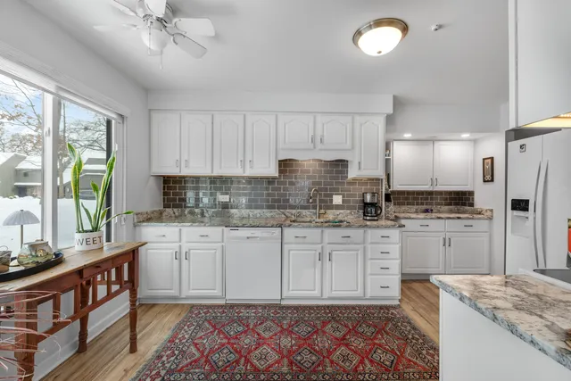 a kitchen with granite countertop cabinets stainless steel appliances a sink and a window