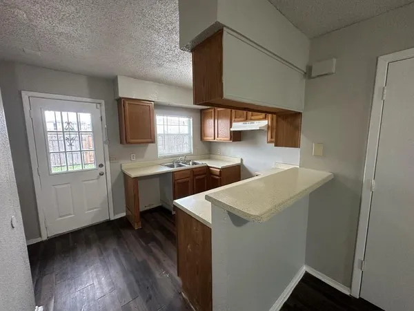 a kitchen with a sink cabinets stainless steel appliances and a window