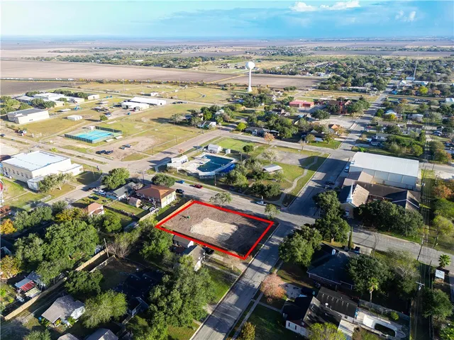 an aerial view of a city with lots of residential buildings ocean and mountain view in back