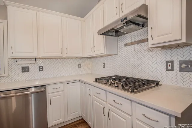 a kitchen with stainless steel appliances granite countertop a sink stove and cabinets