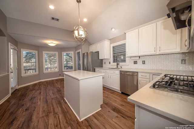 a kitchen with sink a stove and cabinets
