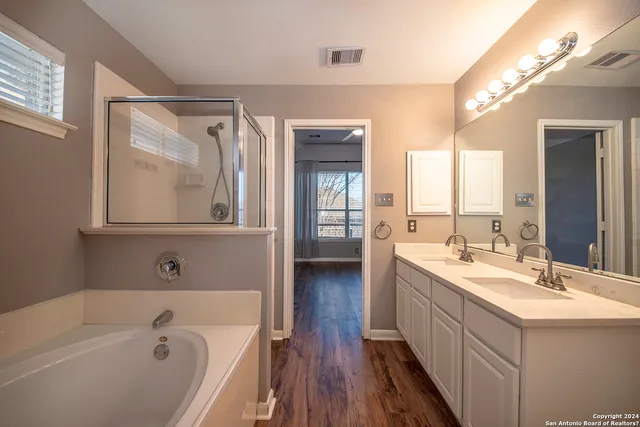 a bathroom with a tub a sink and mirror