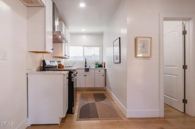 a kitchen with white cabinets and refrigerator