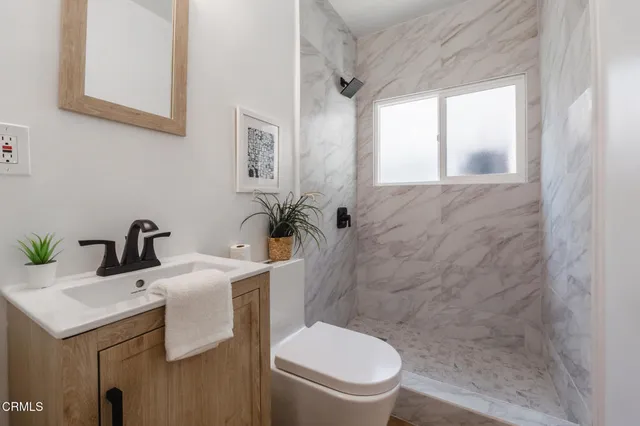 a bathroom with a toilet sink and mirror