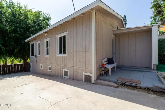 a backyard of a house with wooden fence and trees