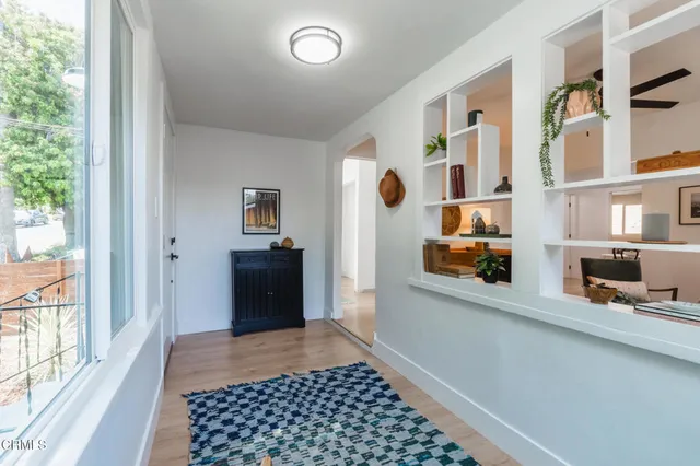 a view of a hallway with wooden floor and windows