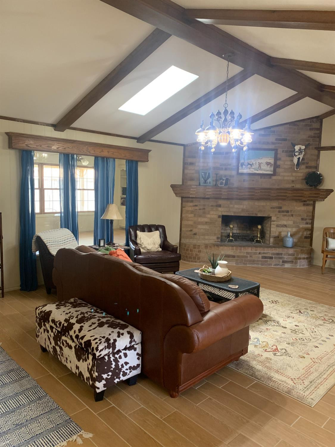 5726 70th Street Lubbock, TX 79424 - Photo 7 of 24 a living room with furniture a fireplace and a chandelier
