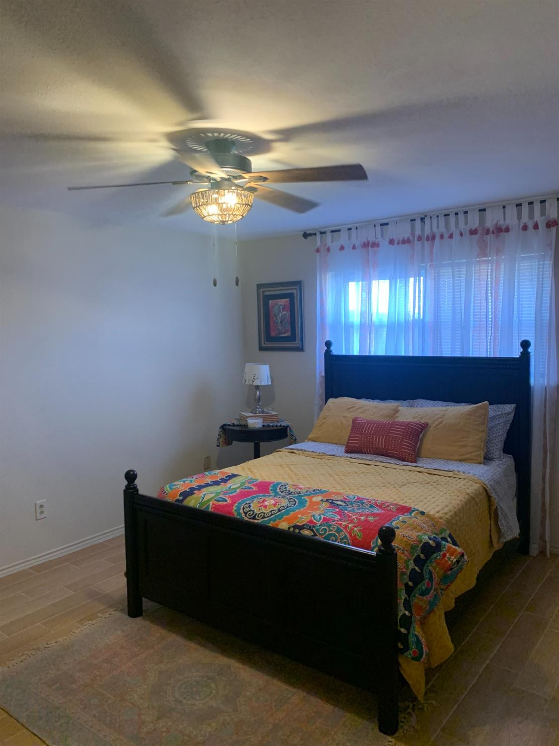 5726 70th Street Lubbock, TX 79424 - Photo 9 of 24 a bedroom with a bed and a chandelier