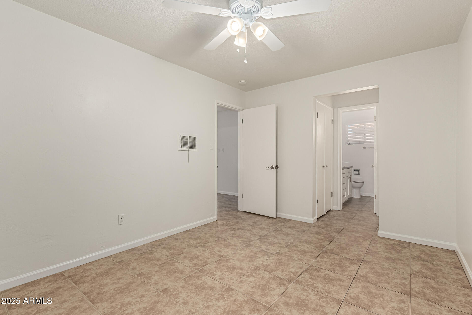 3540 East Montecito Avenue, Unit 3 Phoenix, AZ 85018 - Photo 16 of 23 an empty room with chandelier fan and closet area