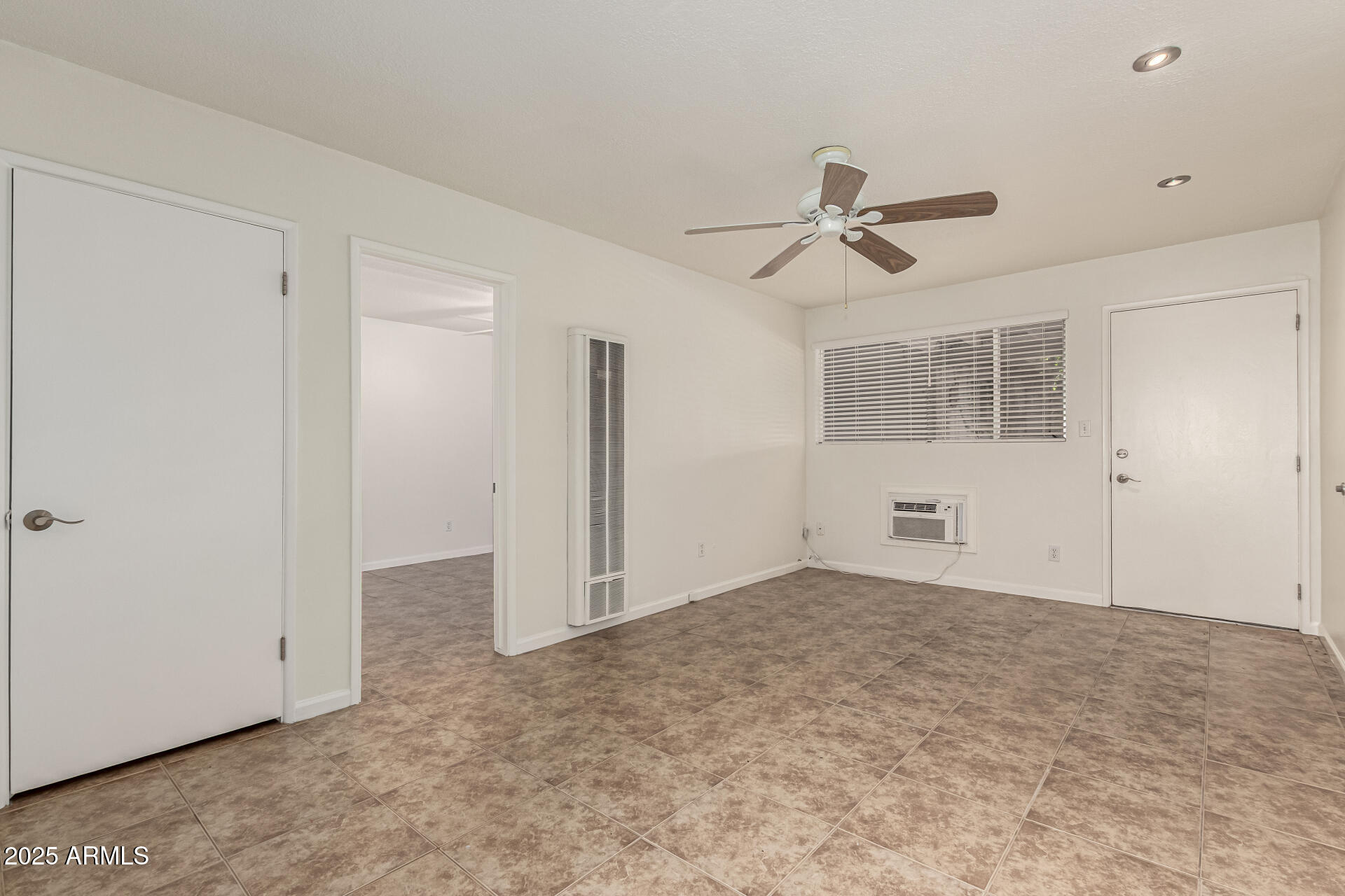 3540 East Montecito Avenue, Unit 3 Phoenix, AZ 85018 - Photo 8 of 23 an empty room with windows and fan